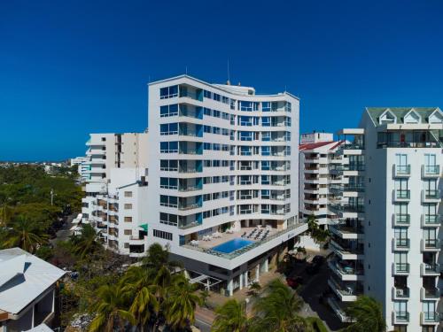 un edificio blanco alto con una piscina frente a él en Samawi Hotel en San Andrés