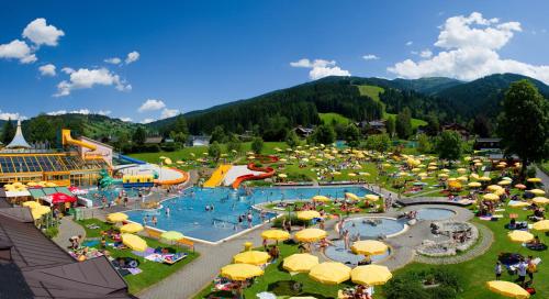 an amusement park with a water park with people and umbrellas at Appartement Fritzenwallner in Wagrain