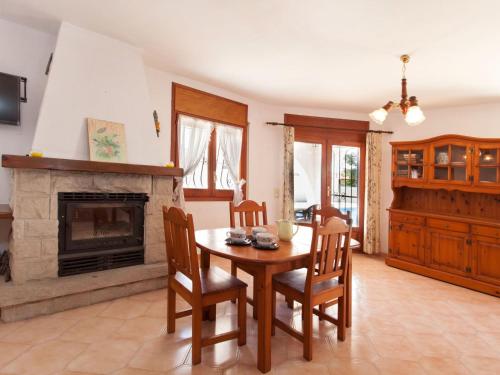 een eetkamer met een tafel en een open haard bij Villa Villa Zozo by Interhome in L'Ametlla de Mar