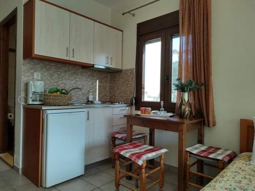 a kitchen with a refrigerator and a table and chairs at AEOLUS Studios in Xerokampos