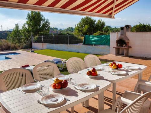 a white table and chairs on a patio with a grill at Villa Villa Malva I by Interhome in Les tres Cales