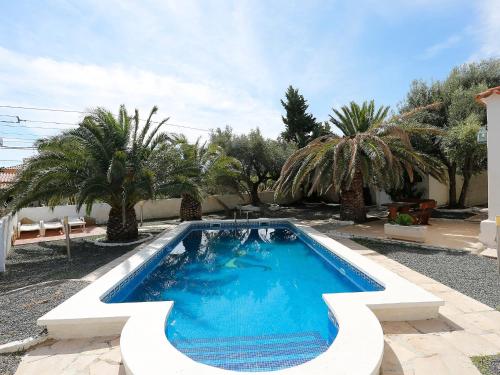 a swimming pool in a yard with palm trees at Villa Arcada by Interhome in Miami Platja