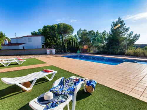 a yard with two lawn chairs and a swimming pool at Villa Villa Malva I by Interhome in Les tres Cales