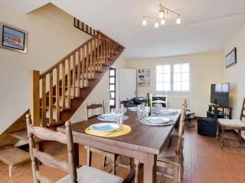 ein Esszimmer mit einem Tisch und einer Treppe in der Unterkunft Holiday Home Penthievre by Interhome in Légenès