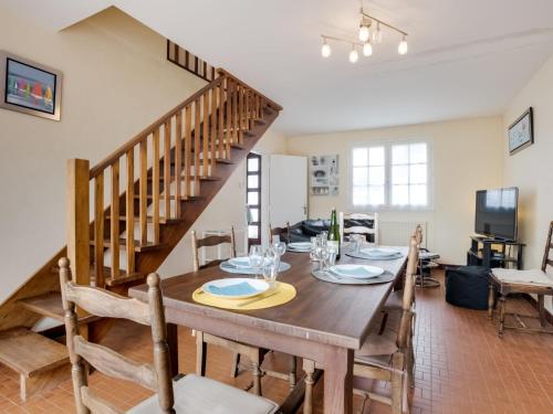 une salle à manger avec une table et un escalier dans l'établissement Holiday Home Penthievre by Interhome, à Légenès