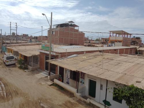 un groupe de bâtiments sur un chemin de terre dans l'établissement Habitaciones Don Pelu, à Máncora