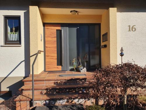 eine Eingangstür eines Hauses mit einer Veranda in der Unterkunft Ferienwohnung am Eck in Amorbach