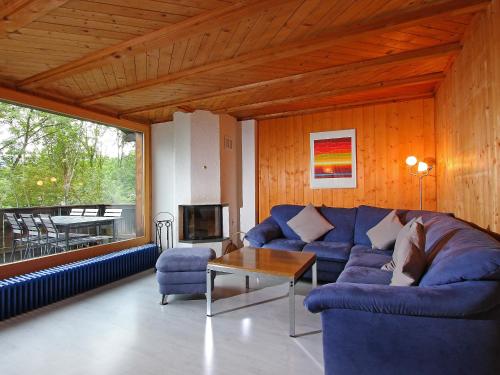 a living room with a blue couch and a table at Chalet Egg-Isch by Interhome in Grindelwald
