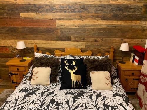 a bed with a black and white comforter with a deer pillow at Bilocale con vista a Sestriere in Sestriere