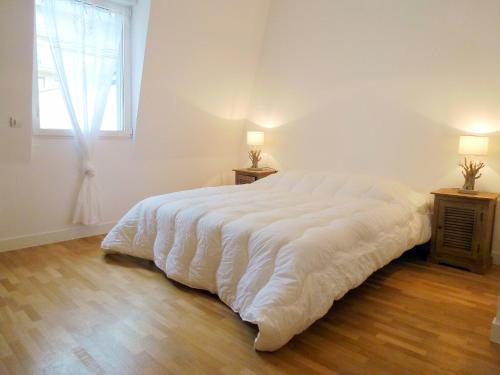 duże białe łóżko w pokoju z oknem w obiekcie Holiday Home Villa Morny by Interhome w mieście Deauville