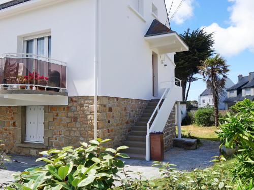 une maison blanche avec des escaliers et un balcon. dans l'établissement Apartment Mer et Soleil by Interhome, à Carnac
