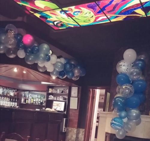 a bunch of balloons on the ceiling of a bar at Discret Hotel & Restaurant in Vladaya