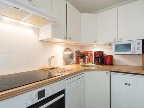 une cuisine avec des armoires blanches et un comptoir dans l'établissement Apartment Plein Soleil-2 by Interhome, à Carnac