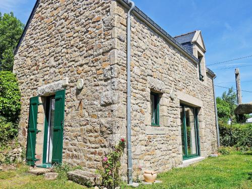 une maison en pierre avec une porte et des fenêtres vertes dans l'établissement Holiday Home Courdiec by Interhome, à Carnac