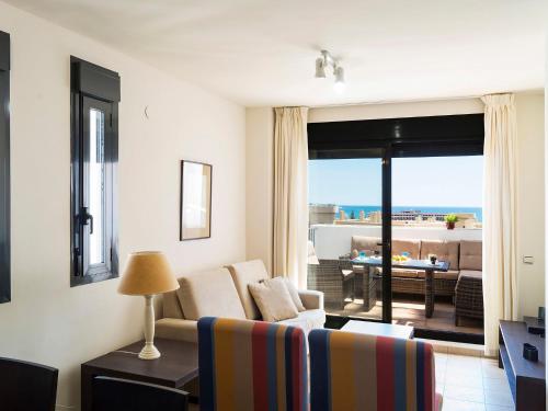 a living room with a couch and a view of the ocean at Apartment Alamar by Interhome in La Cala de Mijas