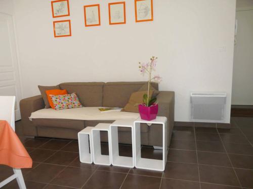 ein Wohnzimmer mit einem Sofa und einem Tisch mit einer Pflanze darauf in der Unterkunft Apartment Nautica by Interhome in Saint-Malo