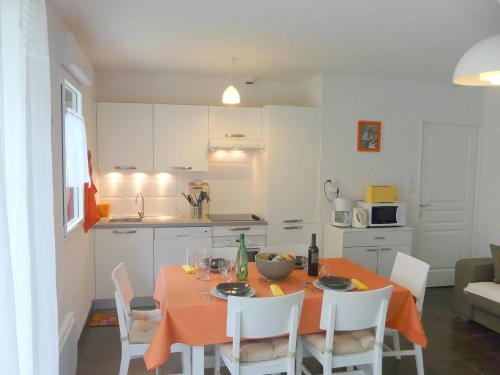 eine Küche mit einem Tisch und einem orangefarbenen Tischtuch in der Unterkunft Apartment Nautica by Interhome in Saint-Malo