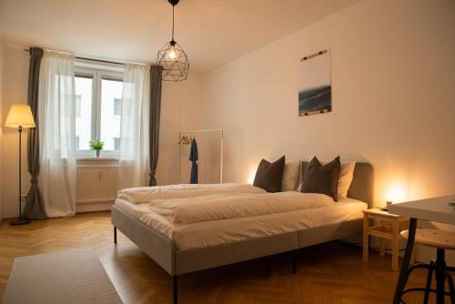 a bedroom with a bed and a table and a window at 2 BR City Apartment in Neubau, 6 min to city center in Vienna