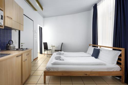 a small bedroom with a bed and a kitchen at GuestHouse Lugano Center by LR in Lugano