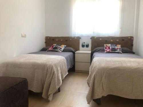 ein Schlafzimmer mit zwei Betten und einem Fenster in der Unterkunft Motorhome beach house in San José