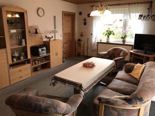 ein Wohnzimmer mit einem Tisch und Stühlen in der Unterkunft Ferienwohnung Klatto in Südbrookmerland