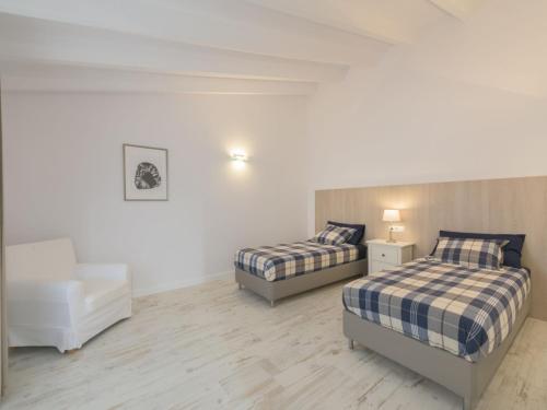 a white room with two beds and a chair at Holiday Home Es Reco by Interhome in Costitx