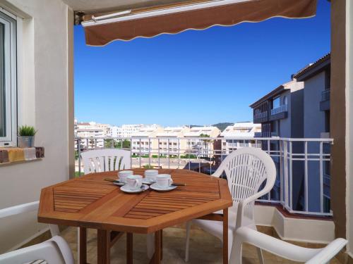 ハベアにあるApartment Arenal Javea-4 by Interhomeの木製テーブル、バルコニー(白い椅子付)