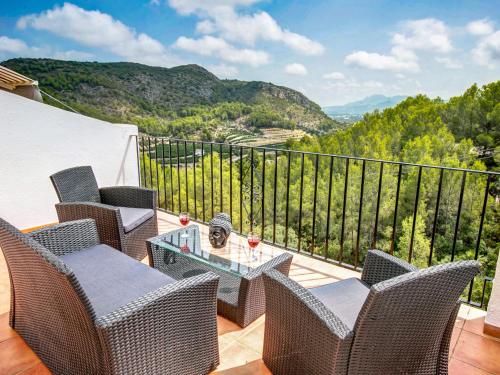 a balcony with wicker chairs and a table with a view at Holiday Home Hope by Interhome in Adsubia