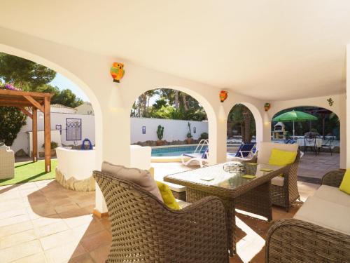 モライラにあるHoliday Home Villa Paradise by Interhomeのパティオ(テーブル、椅子付)、プールが備わります。
