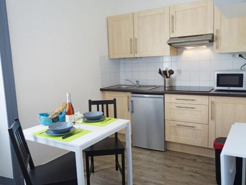 - une cuisine avec une table blanche et de la vaisselle dans l'établissement Apartment Le Continental by Interhome, à Saint-Malo