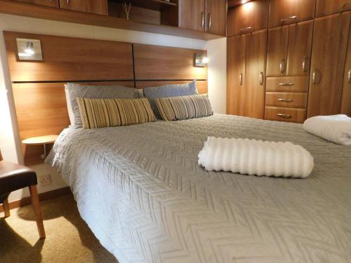 a bedroom with a large white bed with wooden cabinets at Dyfed 23 in Borth