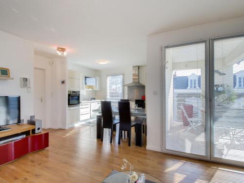 une cuisine et une salle à manger avec une grande porte coulissante en verre. dans l'établissement Apartment Clos Schuman by Interhome, à Saint-Malo