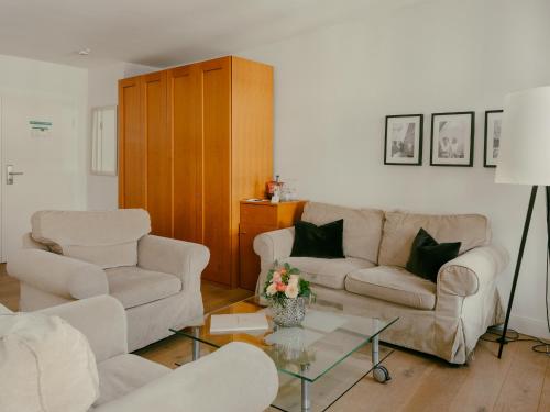 a living room with two couches and a table at Bad Hotel Überlingen in Überlingen