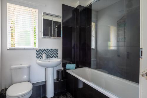 a bathroom with a sink and a toilet and a bath tub at Peaceful Home in Central Saundersfoot with Parking in Pembrokeshire