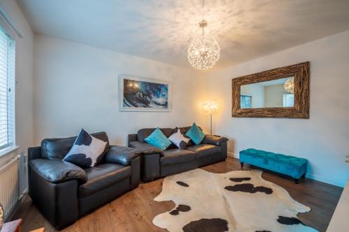 a living room with a leather couch and a mirror at Peaceful Home in Central Saundersfoot with Parking in Pembrokeshire