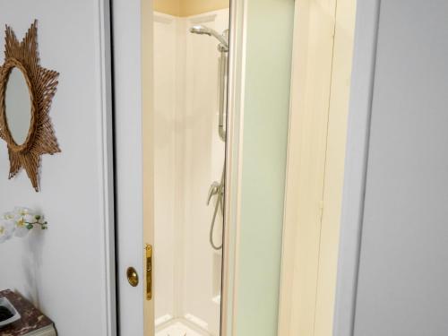 une douche avec une porte vitrée dans une salle de bain dans l'établissement Holiday Home Bel Air by Interhome, à Cancale