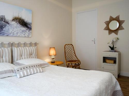 une chambre avec un lit avec un miroir et une chaise dans l'établissement Holiday Home Bel Air by Interhome, à Cancale