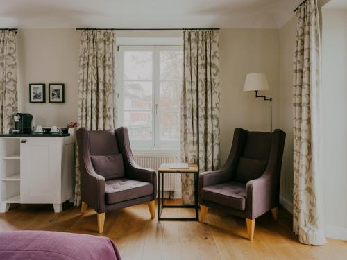 a living room with two chairs and a window at Bad Hotel Überlingen in Überlingen