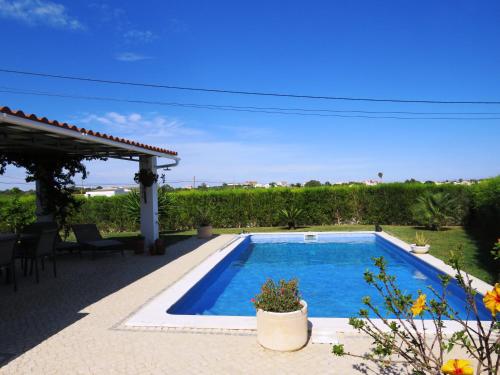 - une piscine dans une cour avec une terrasse dans l'établissement Casa Nokleby - Moradia com Piscina Privada e Jardim, à Altura