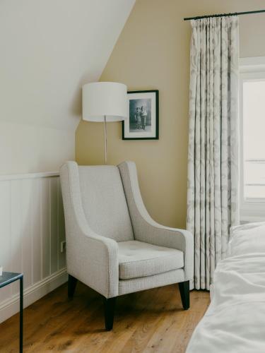 a living room with a chair and a bed at Bad Hotel Überlingen in Überlingen