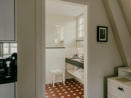 a white kitchen with a sink and a table at Bad Hotel Überlingen in Überlingen