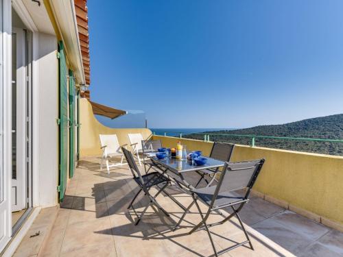 un patio con tavolo e sedie sul balcone. di Holiday Home Le Belvédère by Interhome a Cavalaire-sur-Mer