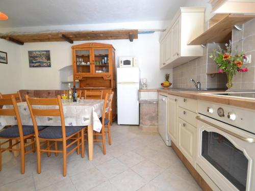 uma cozinha com uma mesa e um frigorífico branco em Holiday Home Kala by Interhome em Sveti Filip i Jakov