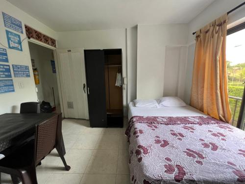 a bedroom with a bed and a desk and a window at Casa Santiago Mayor in Cali