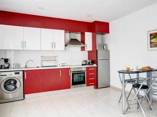 eine Küche mit roten Schränken und einer Waschmaschine in der Unterkunft Apartment Pueblo del Cid-2 by Interhome in Molinell