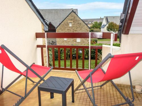 - deux chaises rouges et un tabouret sur le balcon dans l'établissement Apartment Les Reflets de Carnac-1 by Interhome, à Légenès