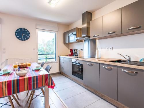 カルナックにあるApartment Stella Marine-1 by Interhomeのテーブルと壁に時計があるキッチン