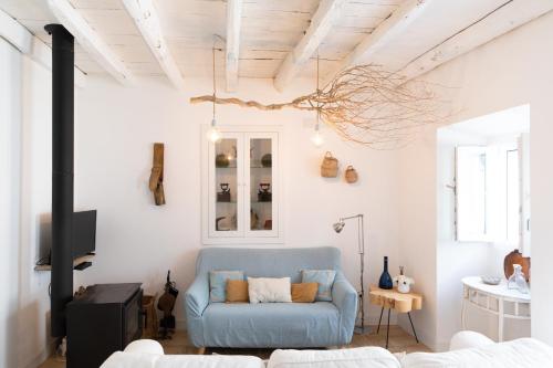 a living room with a blue couch and a tv at Casa da Avó Pam in Alcáçovas
