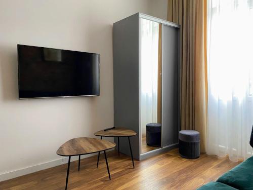 a living room with two tables and a flat screen tv at Apartament 11A- Hvile in Toruń
