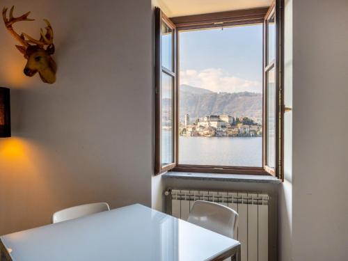 a white table and chairs in a room with a window at Apartment Isola by Interhome in Orta San Giulio